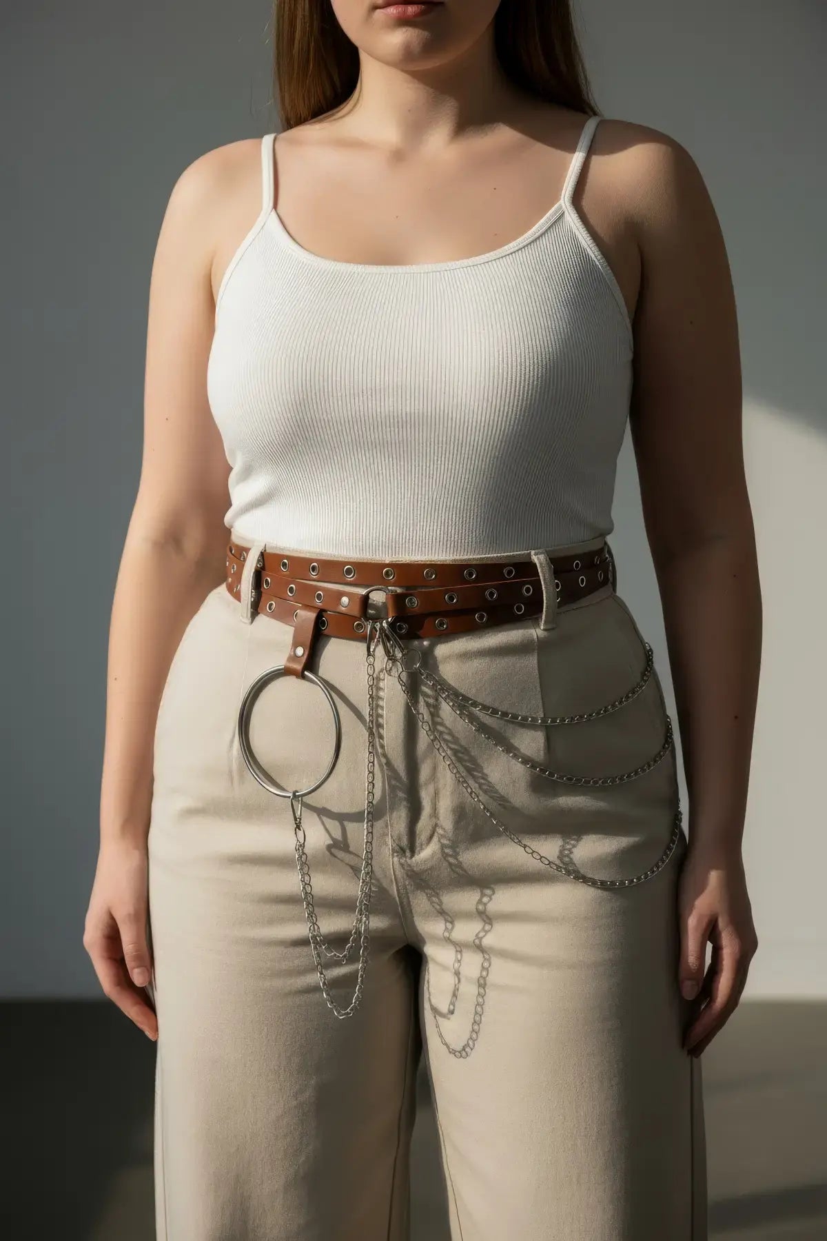 Plus-size tan vegan leather grommet belt with O-ring and chain detail.
