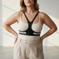 Plus size vegan leather body harness belt in black, worn over a beige ribbed top