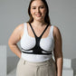 Plus-size vegan leather body harness belt in black worn over a white tank top for festival and clubwear.