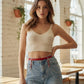 Red vegan-leather chain-drape waist belt by HarnessClub with silver chains, worn over denim.