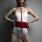 Red vegan leather collar, waist belt and thigh cuffs harness set by HarnessClub worn on a model in a white bodysuit