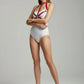 HarnessClub Women's Red Chain & Stud Chest Harness in vegan leather worn over a white bodysuit