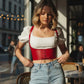 Red vegan leather lace-up underbust corset belt with straps worn over a white puff-sleeve top