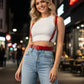Red vegan-leather waist harness with shoulder straps, by HarnessClub, worn over a white crop top.