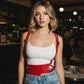 Red studded waist-panel harness by HarnessClub worn over white tank top, vegan leather accessory