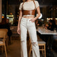 HarnessClub tan vegan leather underbust corset belt with lace-up front and shoulder straps worn over a white tee.