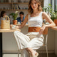 Tan wide O-ring waist belt in vegan leather by HarnessClub, worn by a model in a white top.