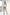 Women's black buckle-detail faux leather leg harness set worn by a model in a white bodysuit.