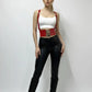 Red vegan-leather corset waist belt with lace-up and suspenders worn by model in a white crop top and black pants