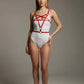 Womens red star-cross chest and underbust harness in vegan leather by HarnessClub, worn over a white bodysuit