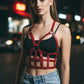 Womens red studded open-cage vegan leather harness worn over a black top by HarnessClub