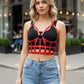 Red vegan leather studded open-cage bust harness worn over a black top.