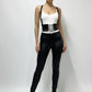 Women's black wide lace-up corset belt with suspenders; vegan leather waist cincher worn over a white top