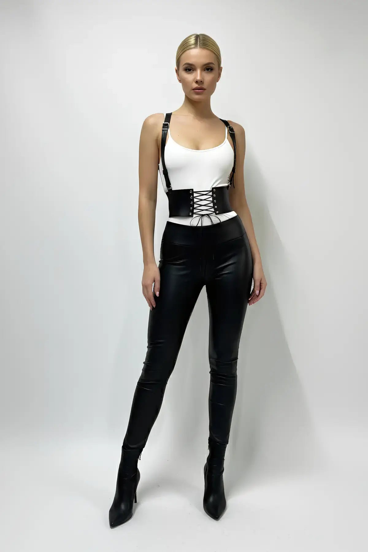 Women's black wide lace-up corset belt with suspenders; vegan leather waist cincher worn over a white top