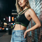 Women's khaki vegan leather buckle harness belt worn over a black crop top