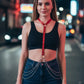 Women's red vegan leather chain-detail O-ring body harness by HarnessClub, worn as choker with waist chains.