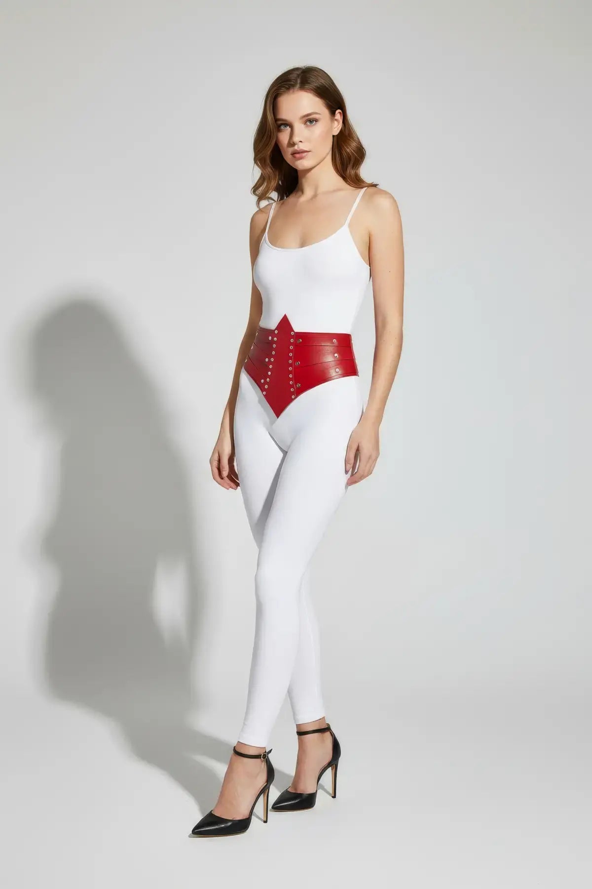 Women's red studded corset belt worn at the waist; vegan leather accessory by HarnessClub
